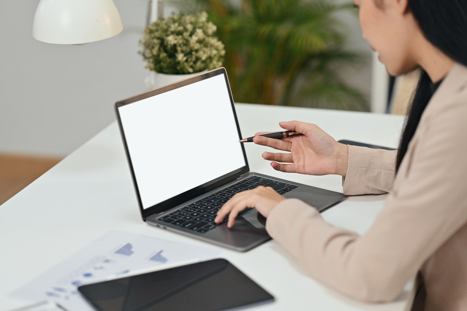 Side view of asian female manager watching online webinar on laptop