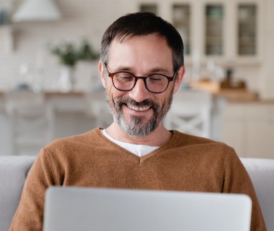 Relaxed middle-aged Caucasian man freelancer father husband watching movies webinars